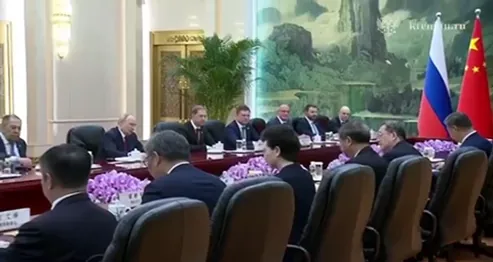 Stretnutie ruských a čínskych predstaviteľov s vlajkami.