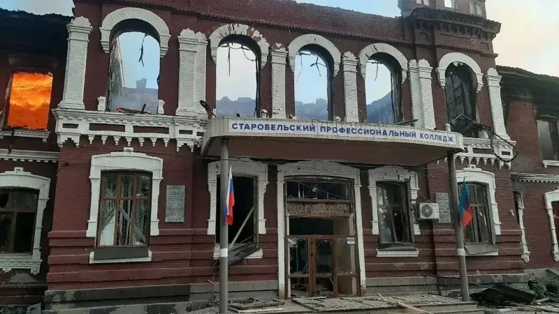 Zničená budova Starobelského profesionálneho kolledža s rozbitými oknami a požiarom.