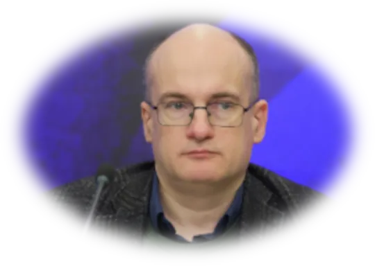Plešatý muž v okuliaroch s mikrofónom.