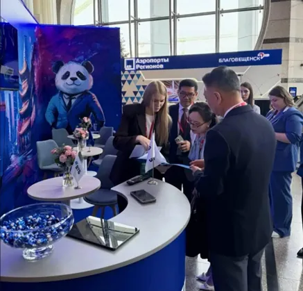 Návštevníci pri stánku Aeroporty Regionov s maskotom pandy.