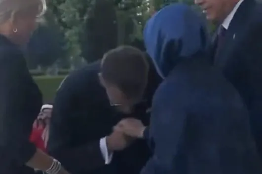 Muž bozkáva ruku usmievajúcej sa ženy.