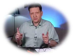 Rečník v košeli gestikuluje, na stole ležia okuliare.